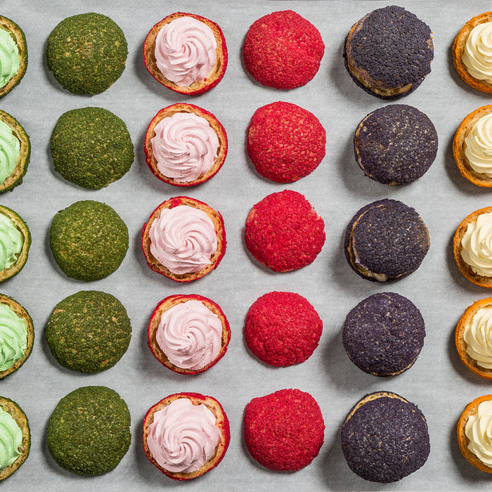 Colourful choux pastries prepared with Macphie Mactop Traditional cream alternative